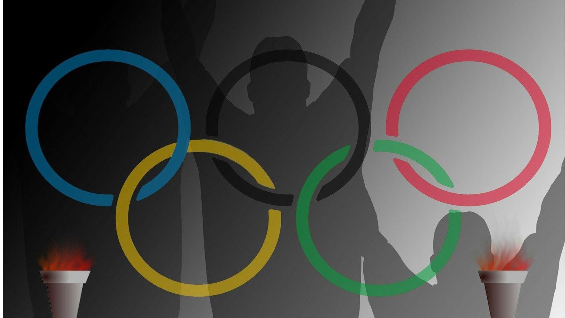 Olympic rings with an outline of an athlete behind the rings